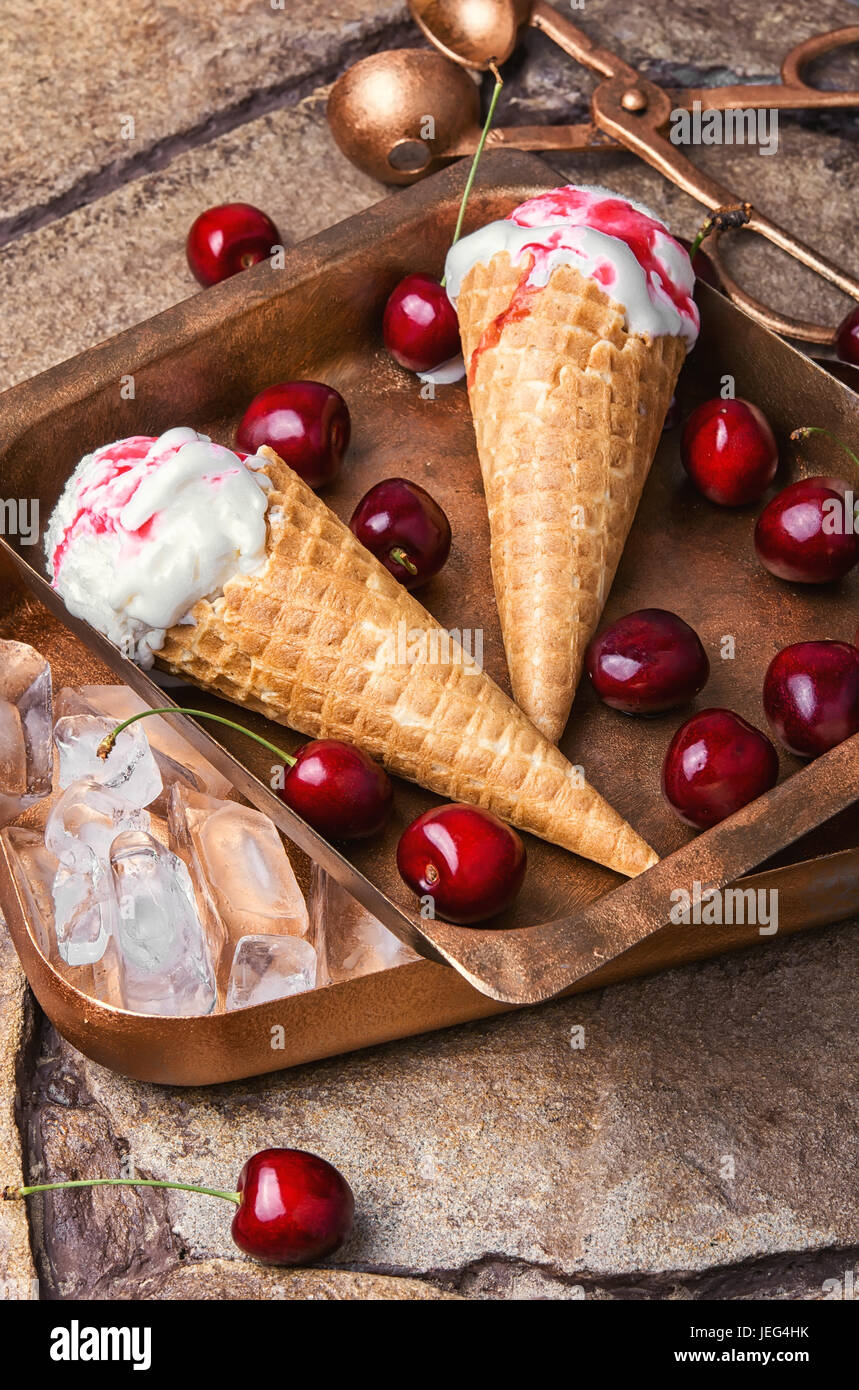 Ice cream in a waffle with cherry jam on stylish stone background Stock Photo