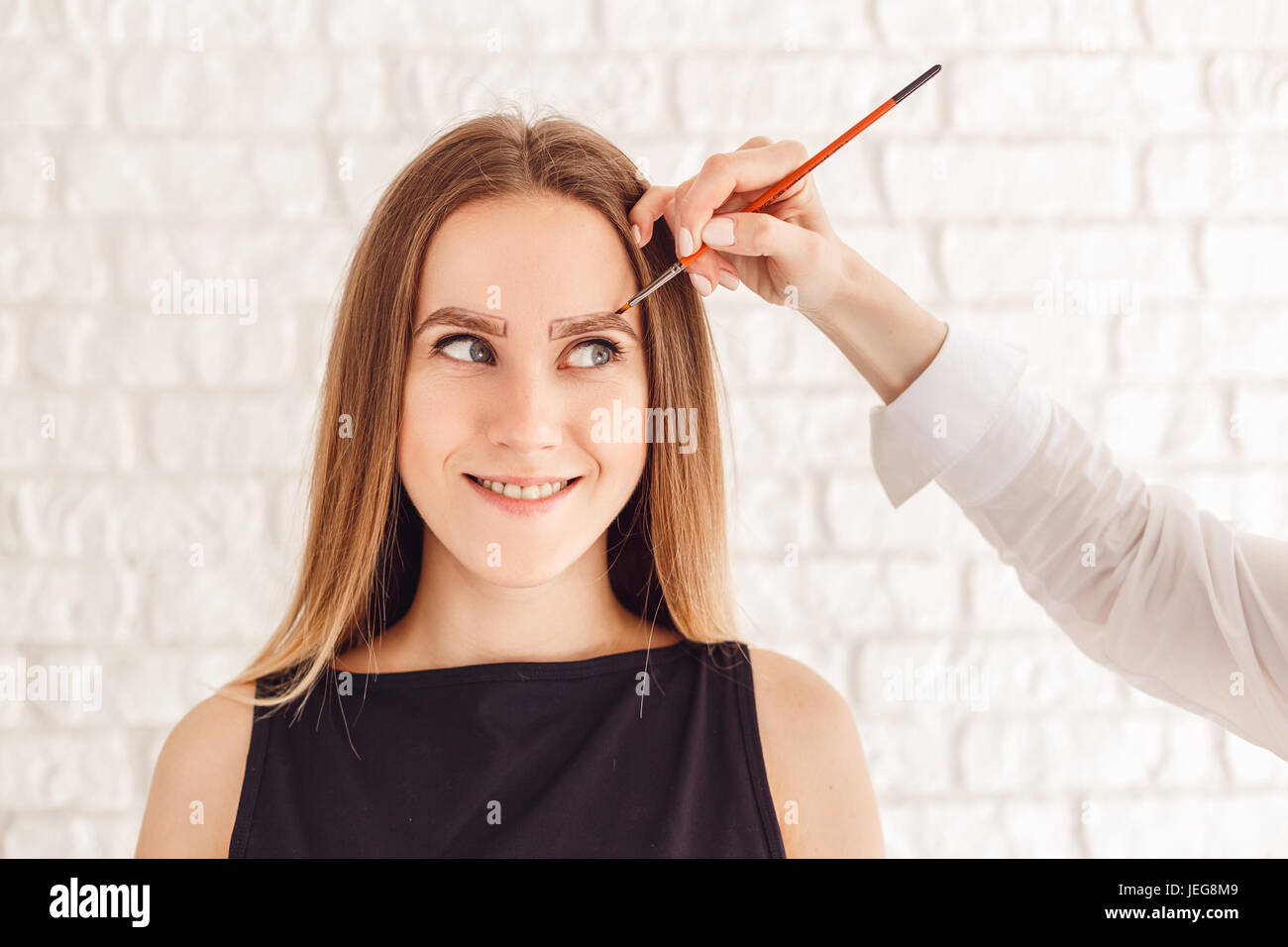Eyebrow correction procedure for the smiling model with long eyelashes Stock Photo