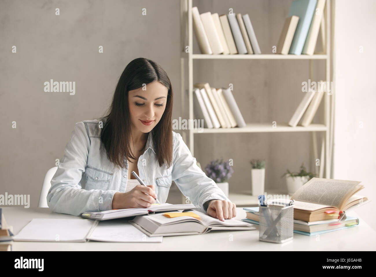 Young woman study at home alone reading a book Stock Photo - Alamy