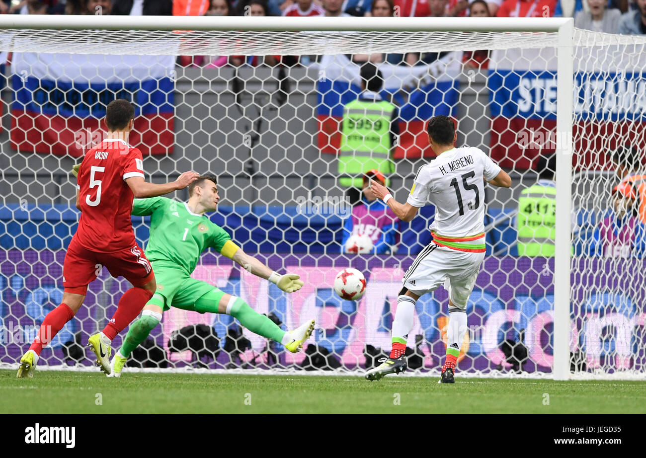 Kazan, Russia. 24th June, 2017. Mexico's Hector Moreno (R) shoots on Russian goalkeeper Igor Akinfeev's (C) goal during the Confederations Cup group stage match pitting Mexico against Russia at the Kazan Arena in Kazan, Russia, 24 June 2017. On the left stands Russia's Viktor Vasin. The putative goal by Moreno was annulled after examination of the video recording. Photo: Marius Becker/dpa/Alamy Live News Stock Photo