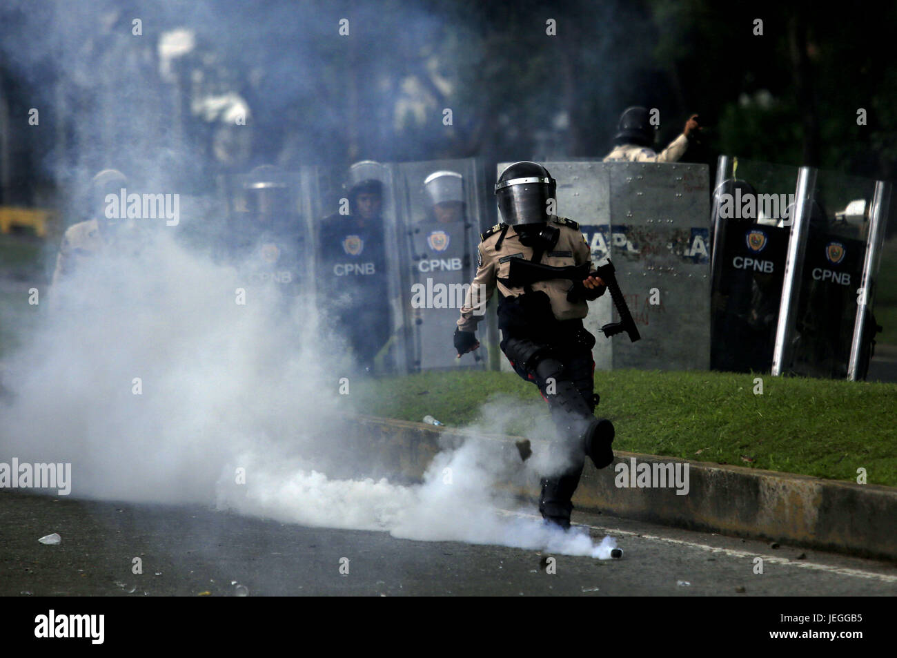 Naguanagua, Carabobo, Venezuela. 24th June, 2017. A member of the Bolivarian national police paket, kicked a lagrinogena bomb returned by the protesters, at the end of the message march to the ff a nn that was a visit to Fort Paramacay, in Naguanagua, Carabobo state. Photo: Juan Carlos Hernandez Credit: Juan Carlos Hernandez/ZUMA Wire/Alamy Live News Stock Photo