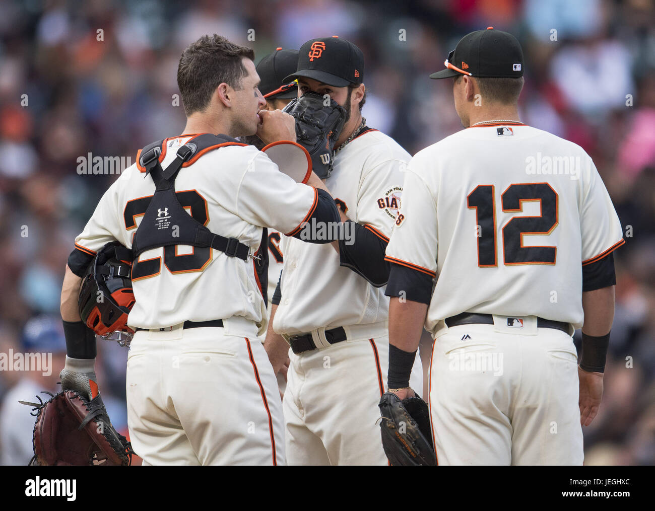 San Francisco, California, USA. 24th June, 2017. Coming into pitch in the top of the eighth inning, San Francisco Giants relief pitcher George Kontos (70) talks with catcher Buster Posey (28) and second baseman Joe Panik (12), during a MLB baseball game between the New York Mets and the San Francisco Giants on ''Giants Retro Bobblehead Day'' at AT&T Park in San Francisco, California. Valerie Shoaps/CSM/Alamy Live News Stock Photo