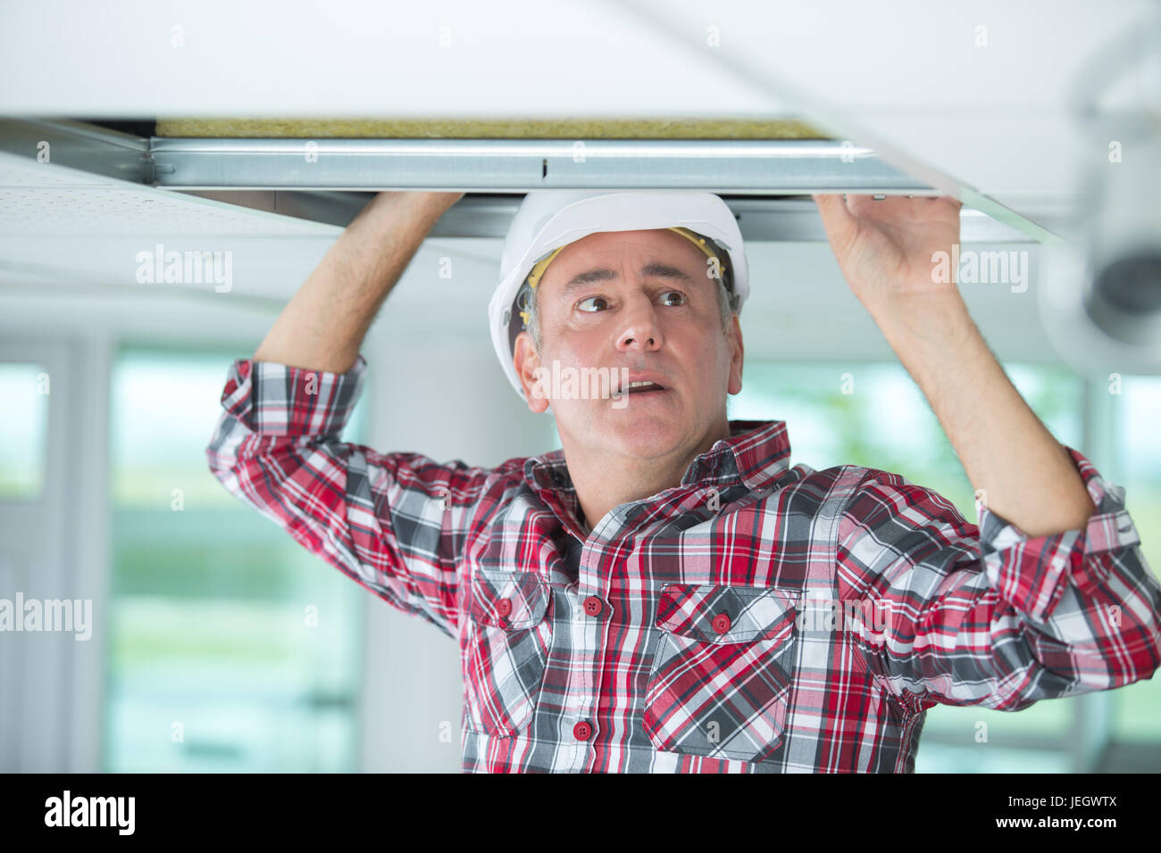 man doing an installation of air conditioner and heating duct Stock Photo