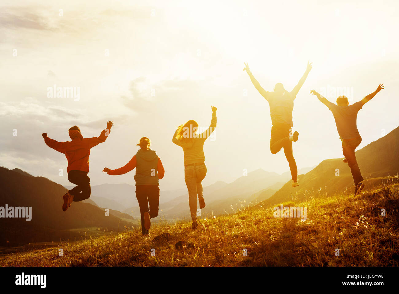 Group of happy friends run and jump Stock Photo