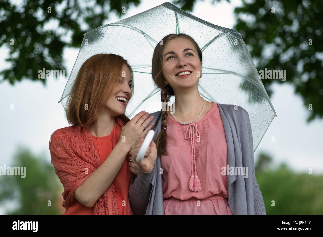 Two women walking park in rain and talk. Friendship and people ...