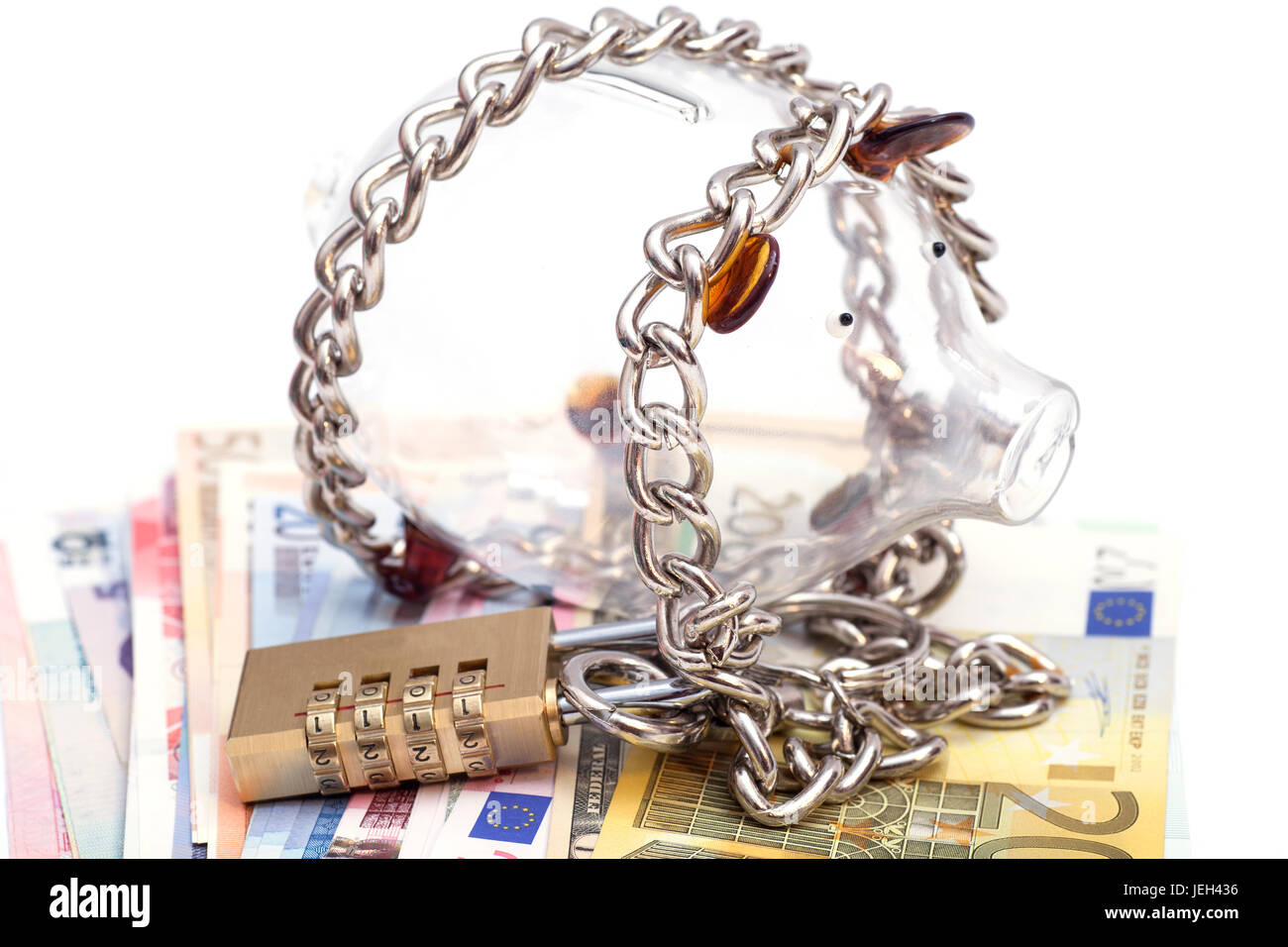 Piggy bank padlocked with chains and padlock on euro banknotes Stock Photo