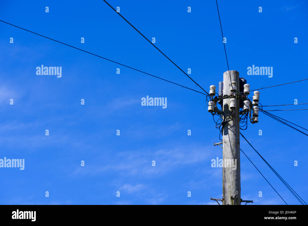 Telephone pole in residential location amid clear blue skies. Llandeilo, Carmarthenshire. Stock Photo