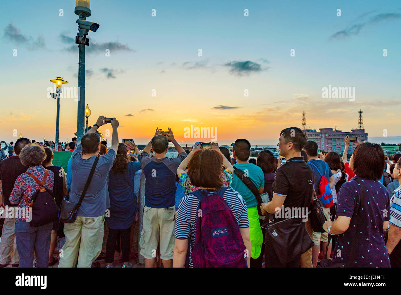 TAIPEI, TAIWAN - MAY 29: Tourists taking photos of the sunset from a pier in the Fisherman's Wharf area of Tamsui on May 29, 2017 in Taipei Stock Photo
