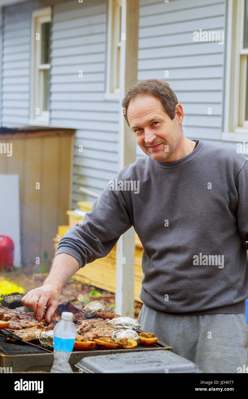 chef grilling lamb ribs on hot flame , barbecue cooking in evening and sunset with wooden Stock Photo