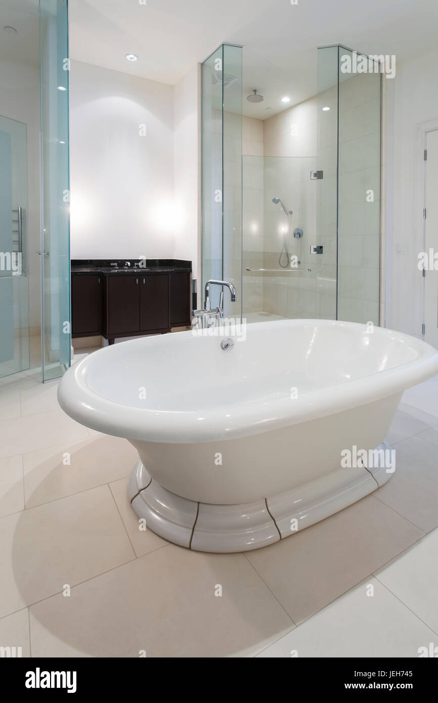 A modern bathroom with a tub floating in the middle of the room and glass  shower doors; Ontario, Canada Stock Photo - Alamy