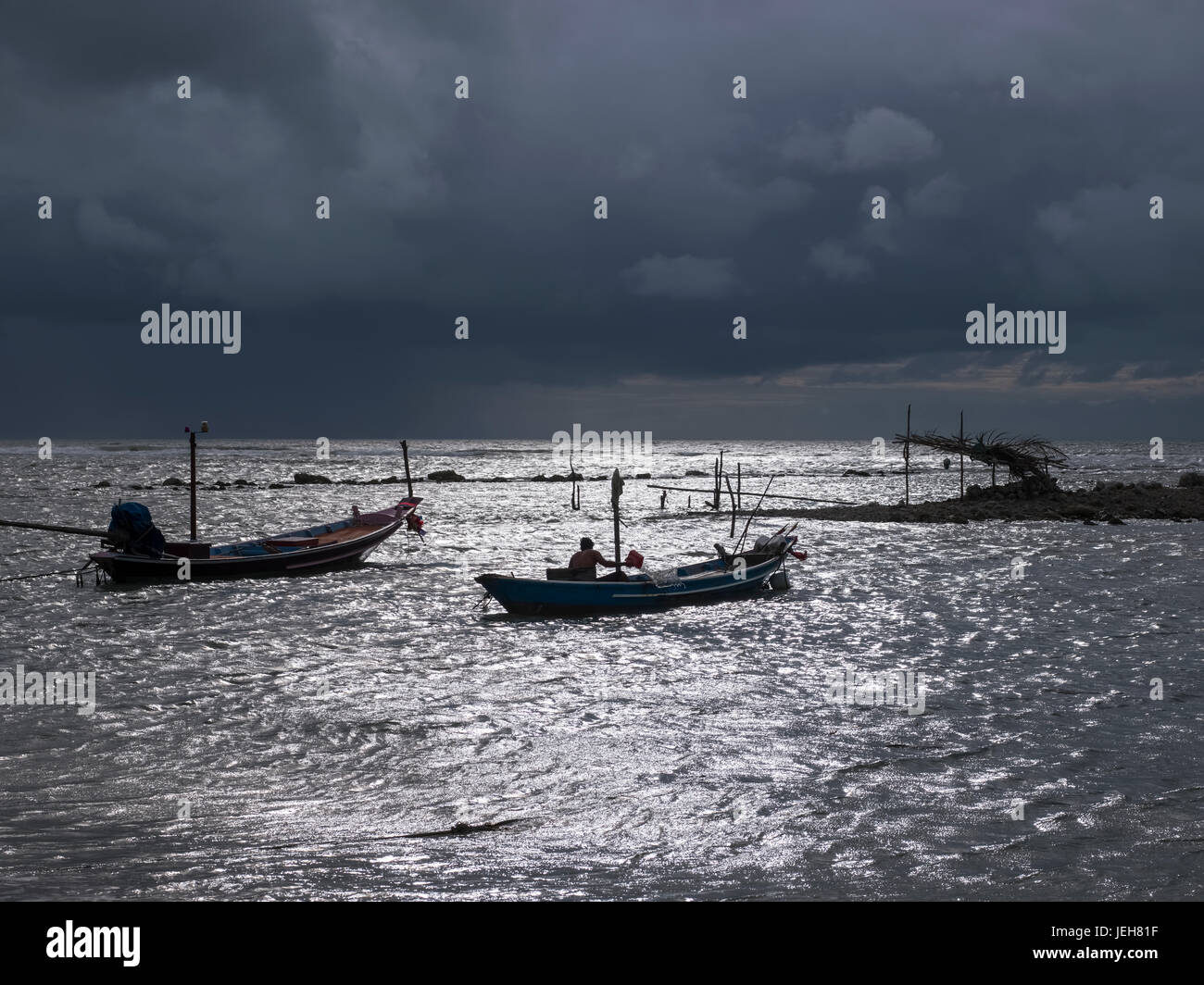 Ominous storm clouds over the Gulf of Thailand with small fishing boats in the water off the shore; Ko Samui, Chang Wat Surat Thani, Thailand Stock Photo