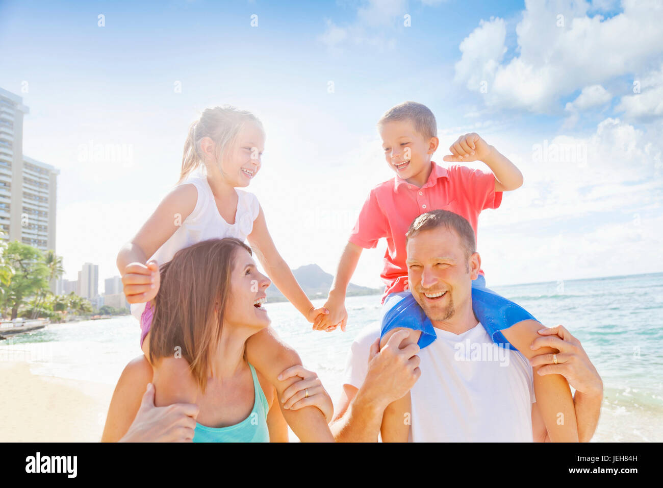 Family of four enjoying a summer vacation in Waikiki Beach; Honolulu, Oahu, Hawaii, United States of America Stock Photo
