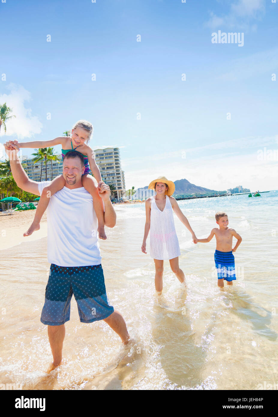A family of four enjoying a summer vacation in Waikiki Beach; Honolulu, Oahu, Hawaii, United States of America Stock Photo
