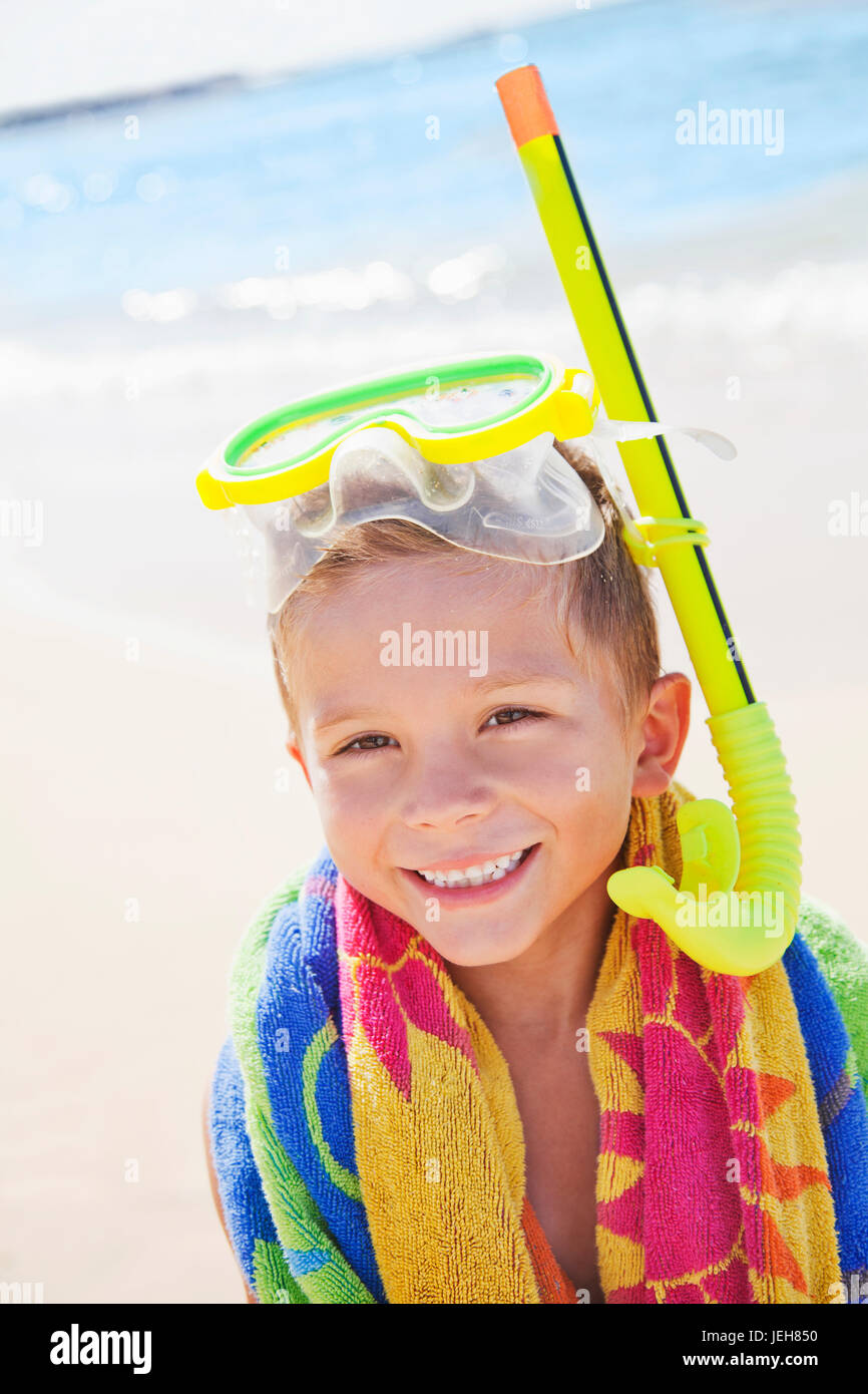 A young boy smiling with snorkel gear at the beach; Honolulu, Oahu, Hawaii, United States of America Stock Photo