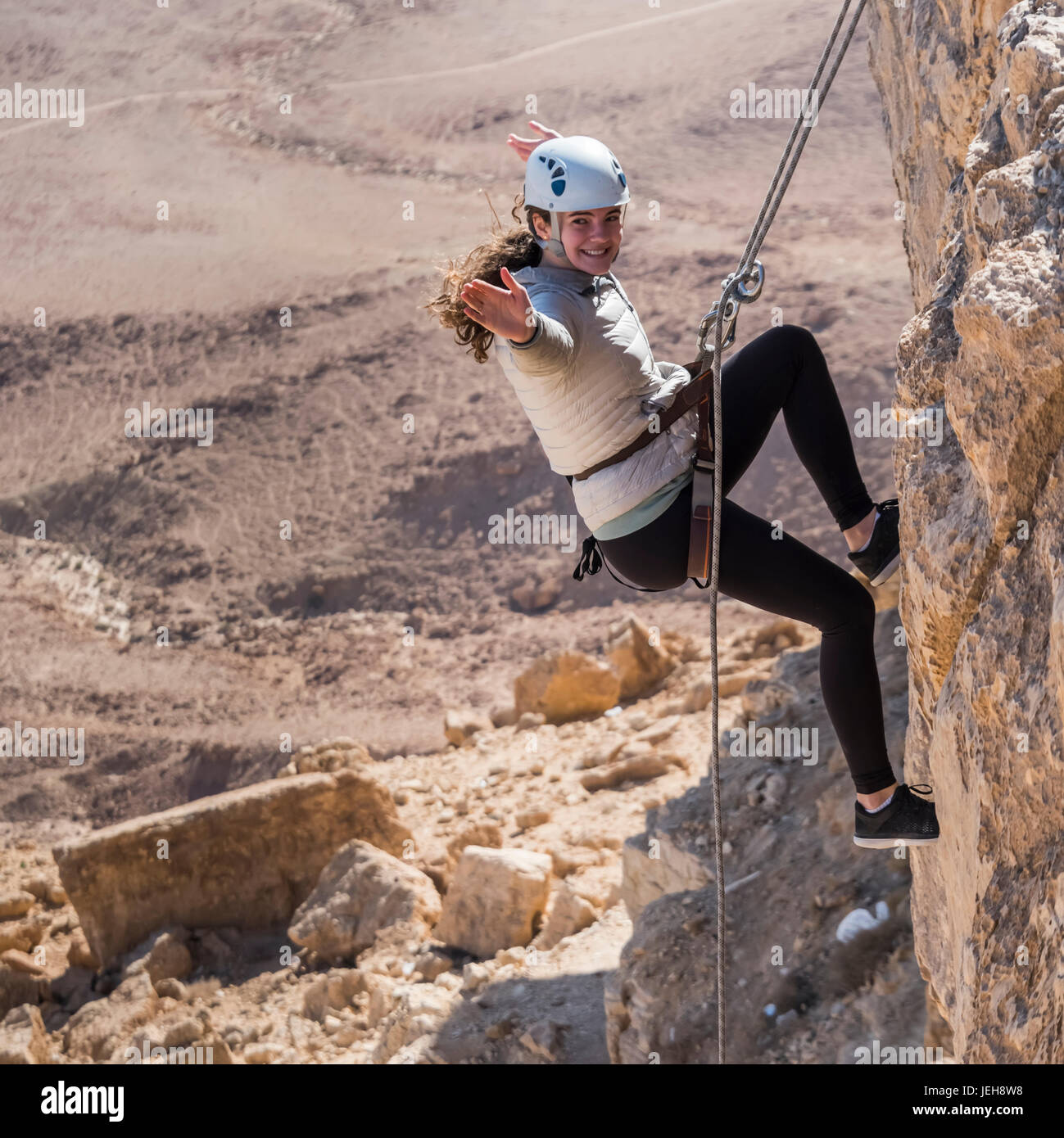 A young woman rappelling into Ramon Crater, Ramon Nature Reserve ...