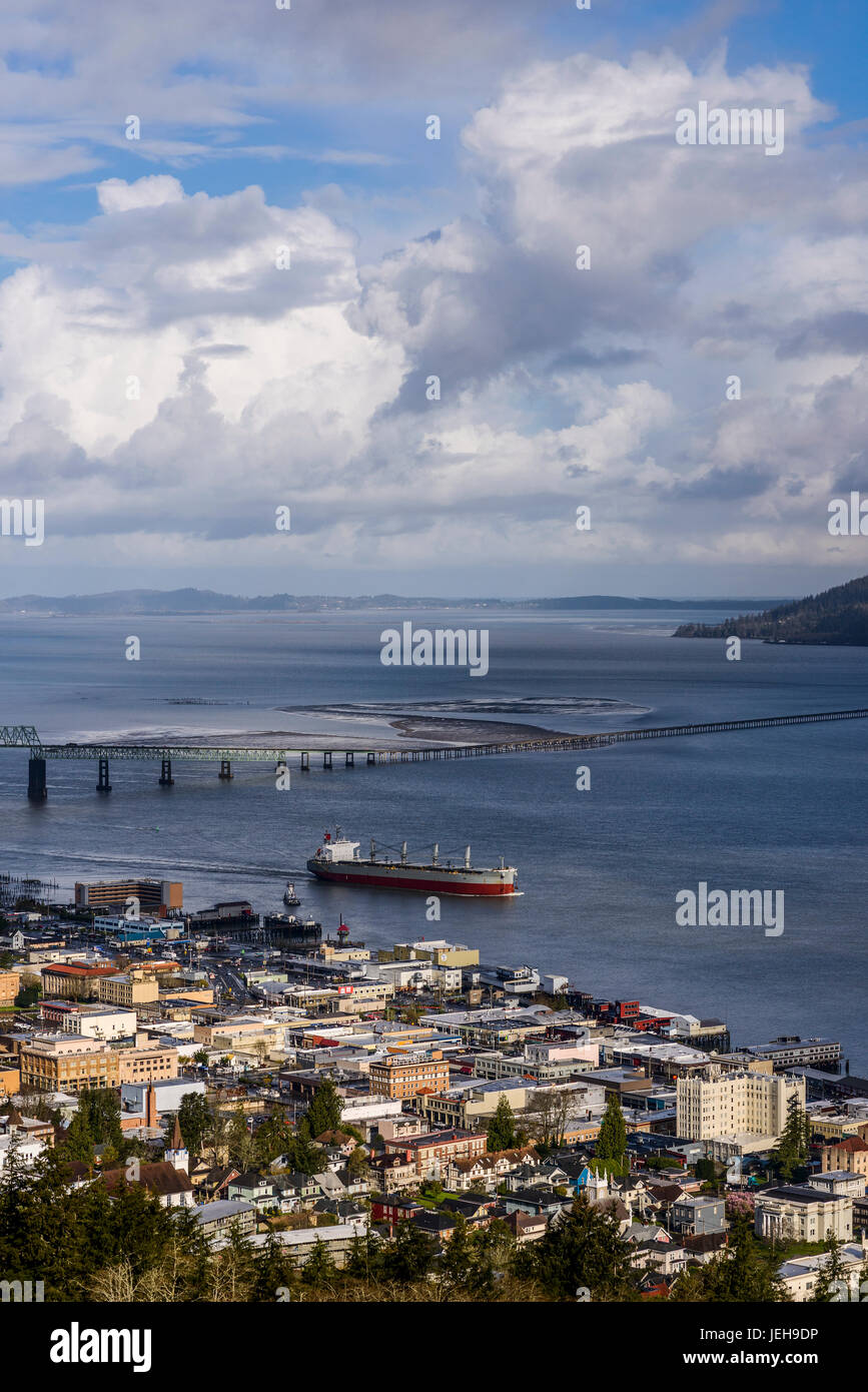 A ship passes the Astoria waterfront on a cloudy morning; Astoria, Oregon, United States of America Stock Photo