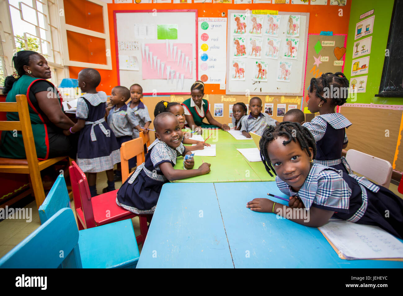 Young children in a classroom with a teacher at the Treasures Christian Preschool; Kampala, Uganda Stock Photo