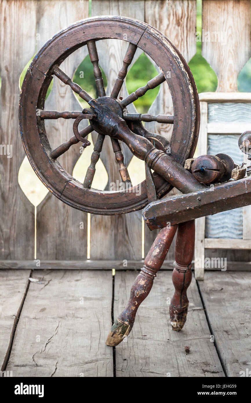 Old sewing spindle is standing on the terrace of an old wooden 