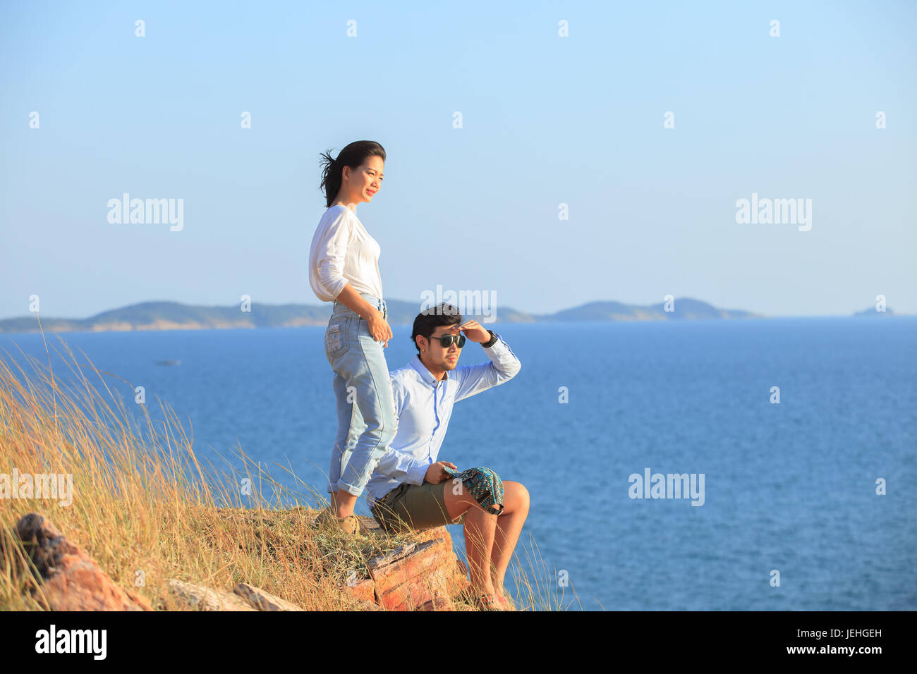 portrait of asian younger man and woman relaxing vacation at sea side happiness emotion Stock Photo