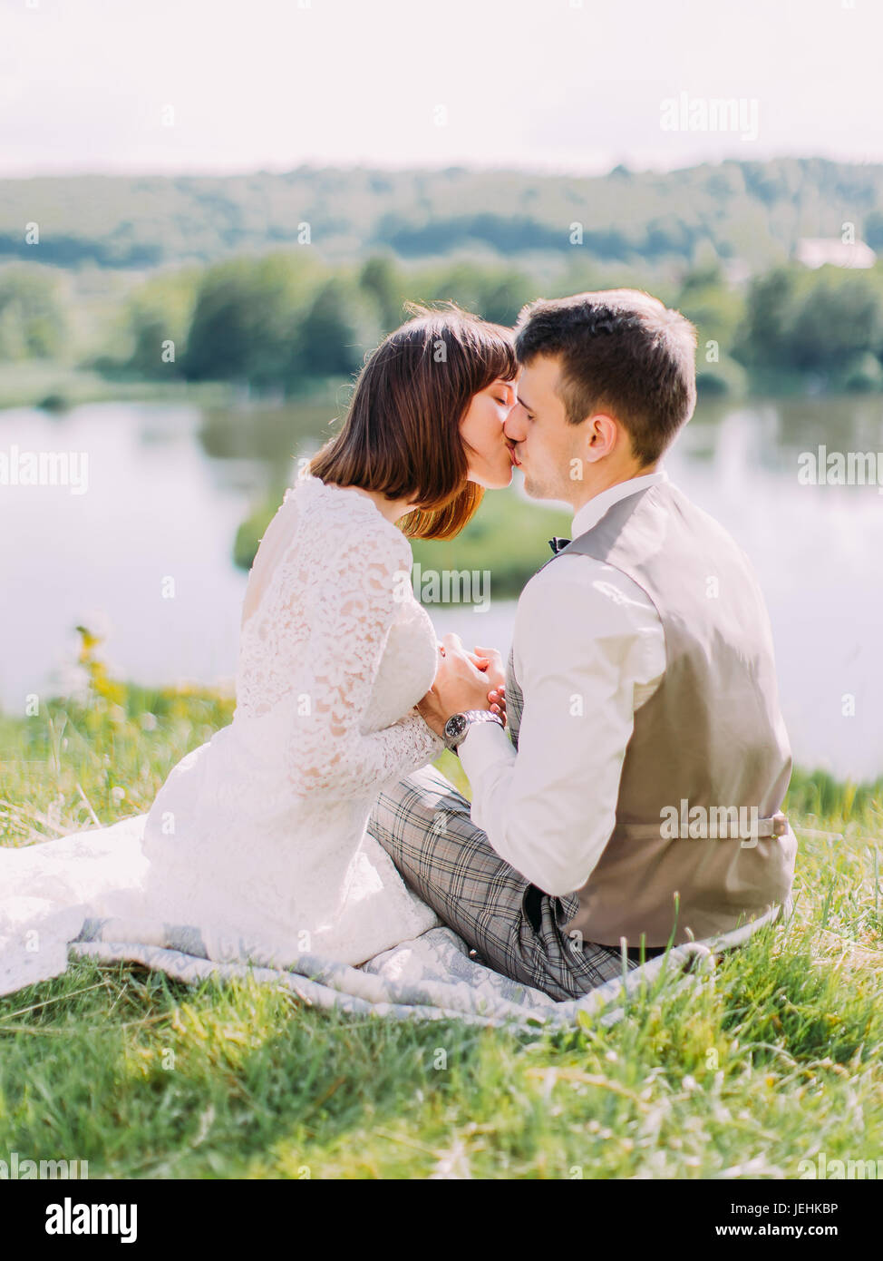 Back newlyweds hugging sitting hi-res stock photography and images - Alamy