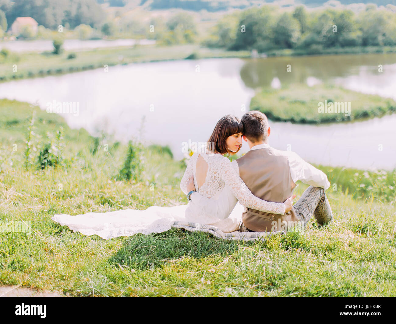 Back newlyweds hugging sitting hi-res stock photography and images - Alamy