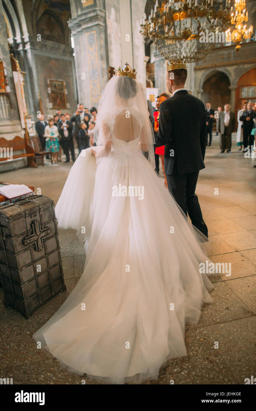 The back view of the long wedding dress of the bride and groom during ...