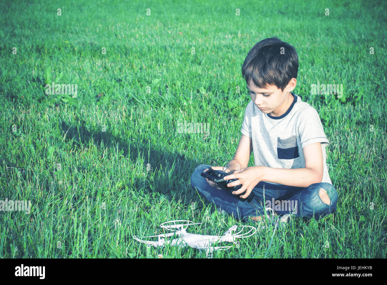 Boy with drone sitting on the grass Stock Photo - Alamy