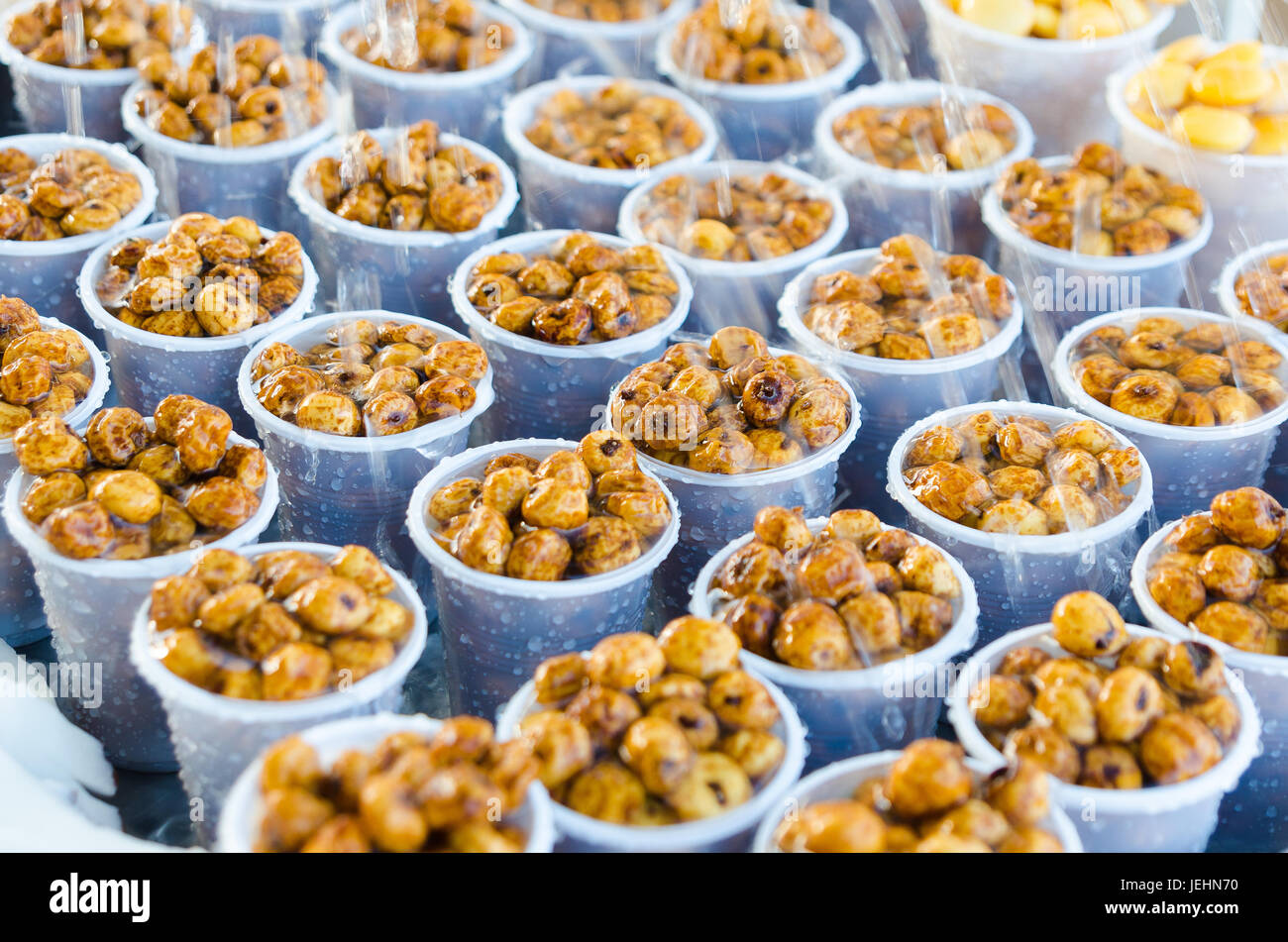 delicious tiger nuts in plastic glasses watered with water. Stock Photo