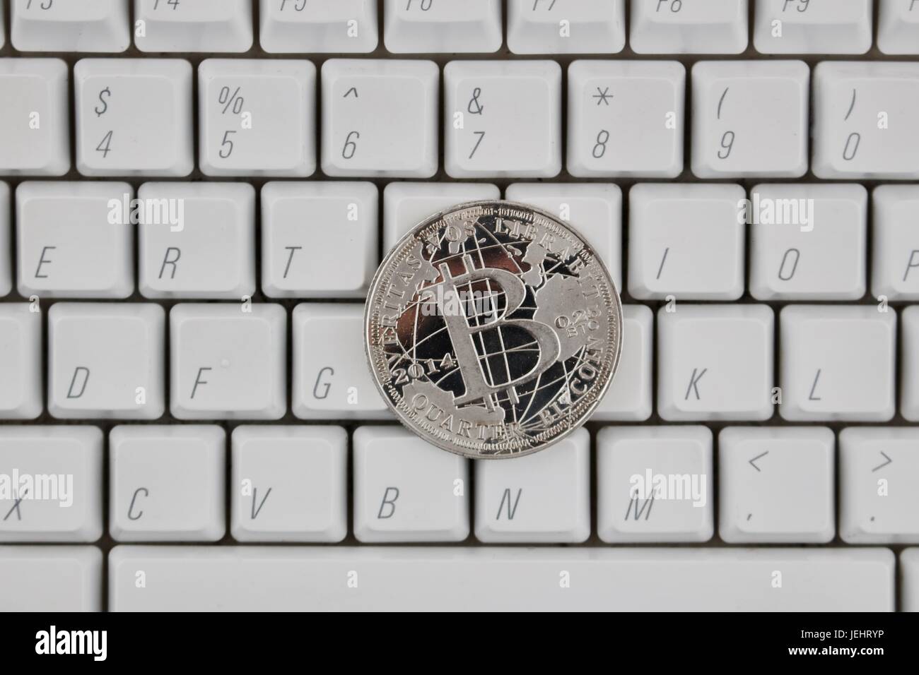 Cryptocurrency physical silver bitcoin coin on the white keyboard Stock ...
