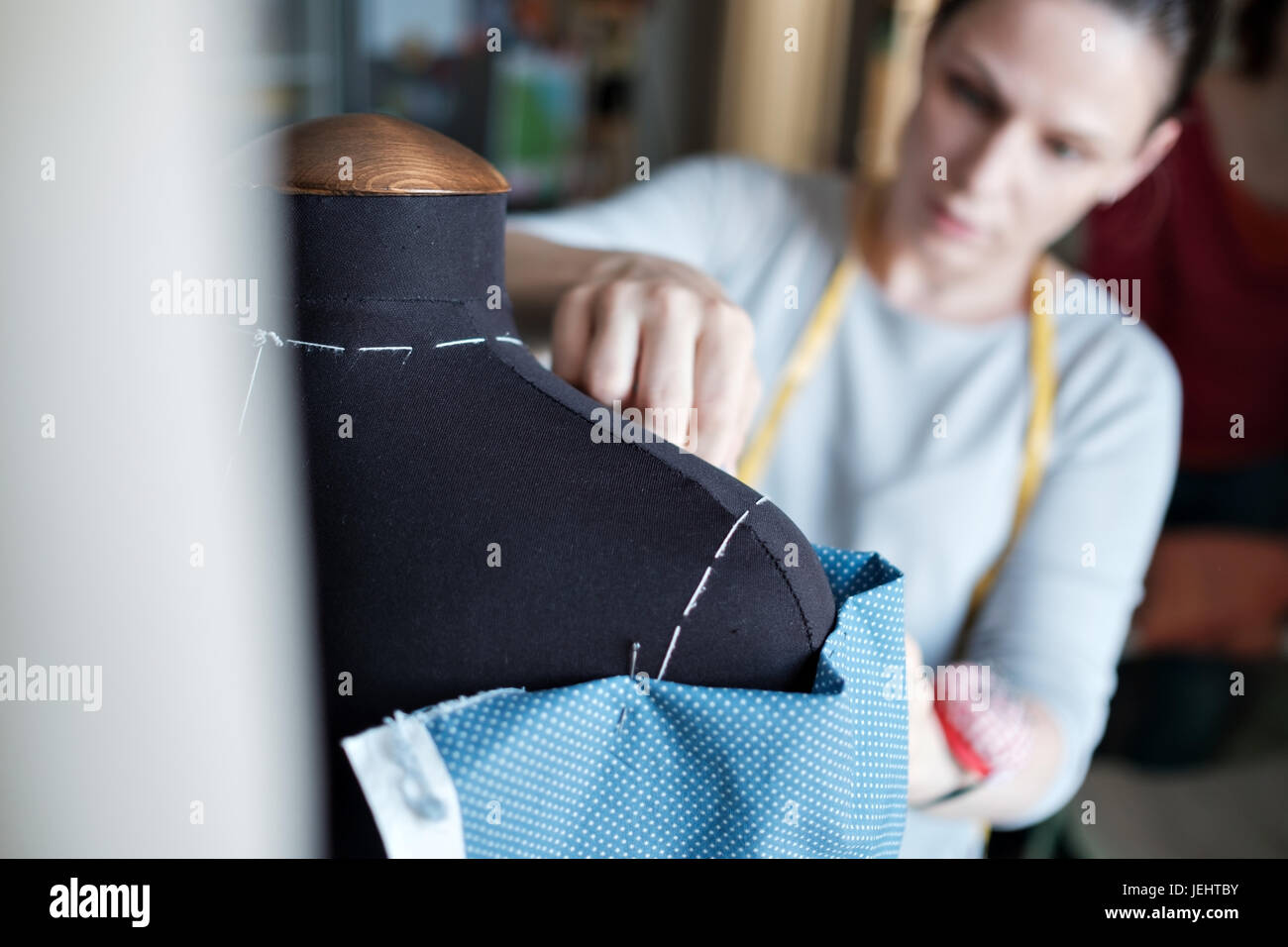 Young caucasian female fashion designer measuring a dress Stock Photo ...