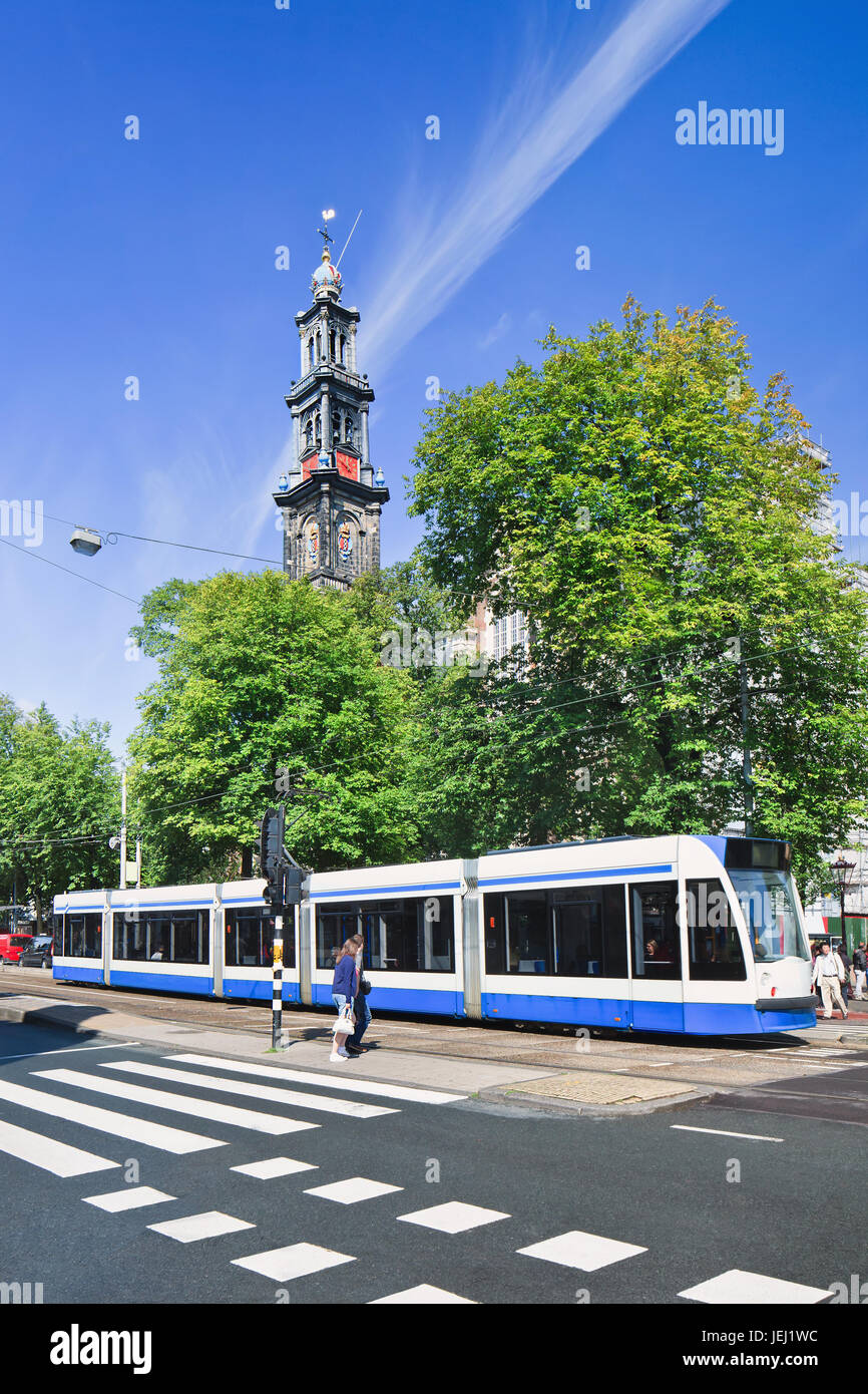 AMSTERDAM-AUGUST 24, 2014. Tram with Wester Tower on background. Transport in the city exist mainly by bicycle and public transport. Stock Photo