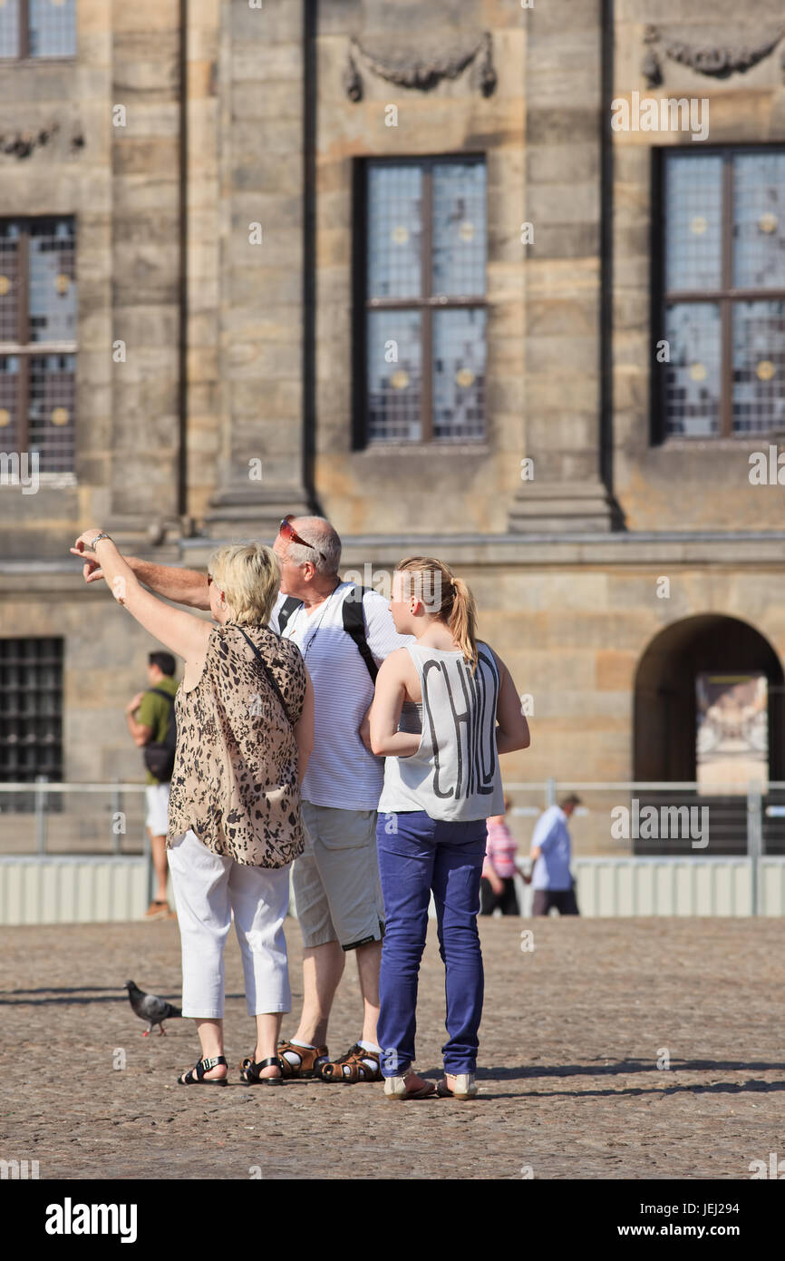 AMSTERDAM-AUGUST 20, 2012. Tourists on Dam Square. The famous square with the neoclassical Royal Palace is one of the most well-known attractions. Stock Photo