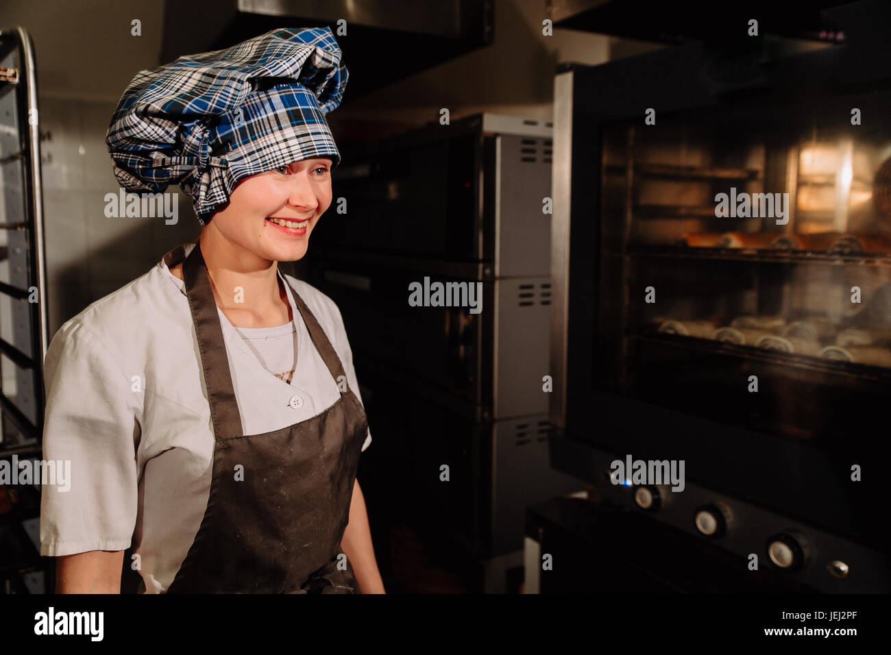 https://c8.alamy.com/comp/JEJ2PF/happy-baker-near-the-stove-smiling-JEJ2PF.jpg