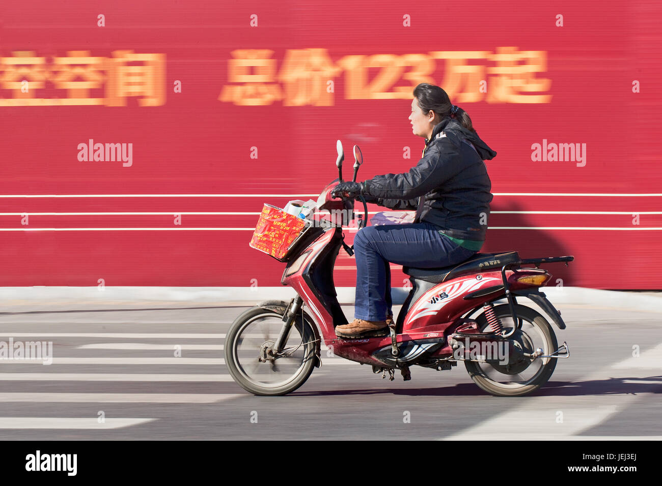 BEIJING – OCT. 25, 2011. Citizen on an electric scooter. Many Beijing residents buy battery-powered two wheel bikes to avoid traffic jam. Stock Photo