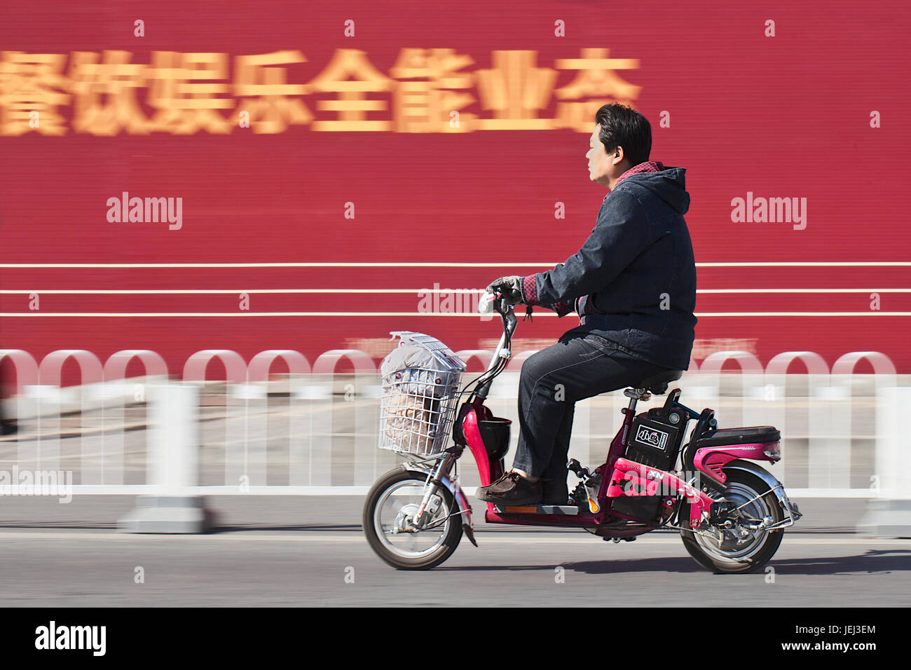 BEIJING – OCT. 25, 2011. Man on electric bicycle in Beijing. Many Beijing residents buy battery-powered two wheel bikes to avoid traffic jam. Stock Photo