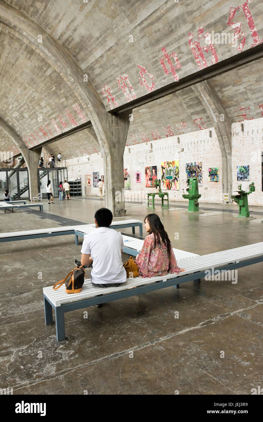BEIJING – SEPT. 5, 2009. Couple in a gallery in Beijing Dashanzi Art District which houses an artistic community, among old factory buildings. Stock Photo