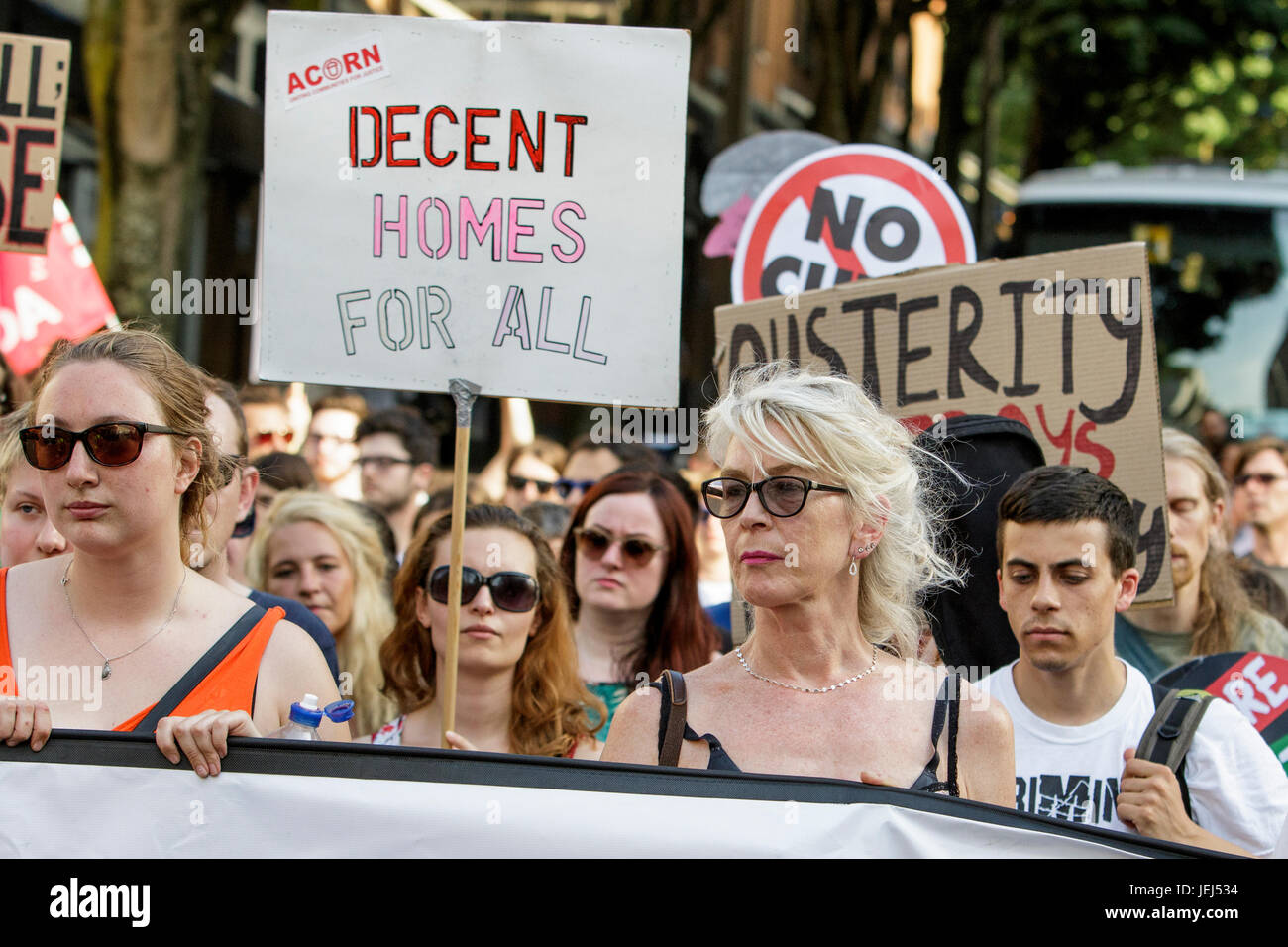 Protesters carrying placards and signs are pictured as they take part in a  Austerity kills, Justice for Grenfell protest march in Bristol. Stock Photo