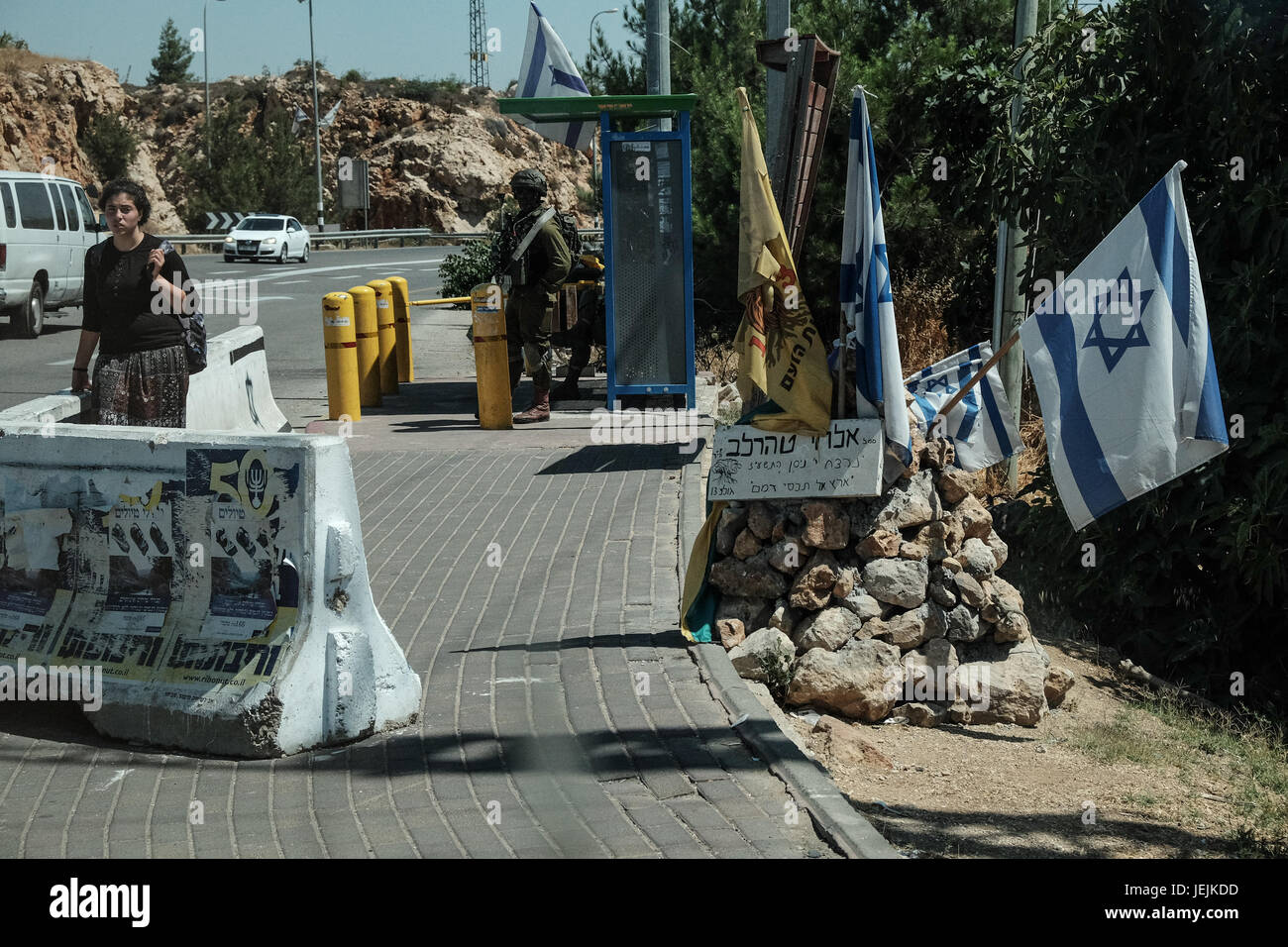 Ofra, West Bank. 26th June, 2017. West Bank settlement Ofra residents, lacking public transportation and reliant on hitchhiking, do so behind concrete barriers and under IDF security at the Ofra Junction. Credit: Nir Alon/Alamy Live News Stock Photo