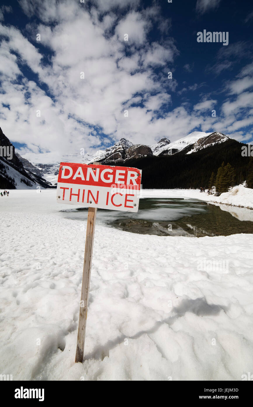 Sign warning of the danger posed by thin ice at Lake Louise in Alberta, Canada. Stock Photo