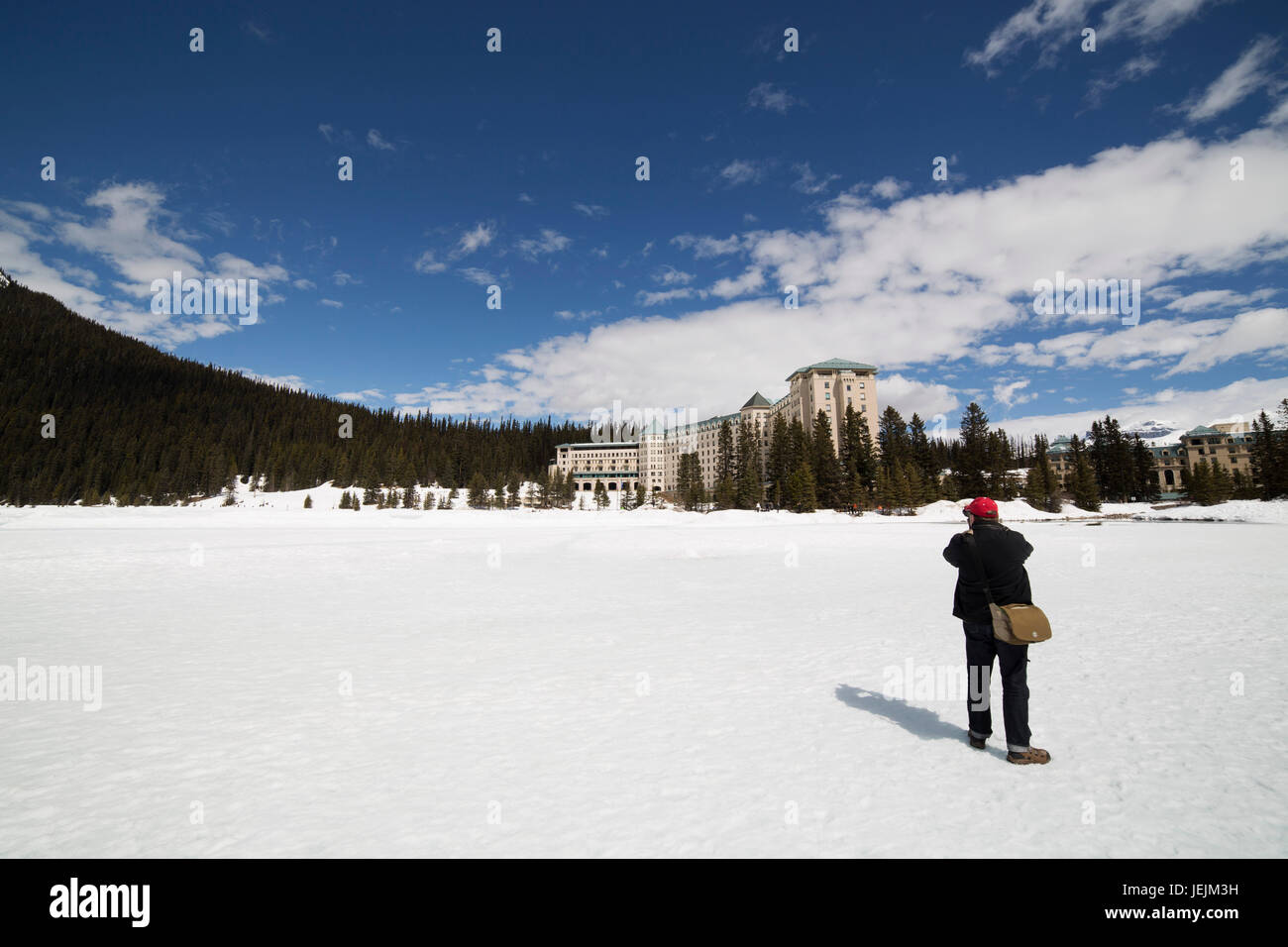 A man photographs the Fairmont Chateau Lake Louise hotel at Lake Louise ...