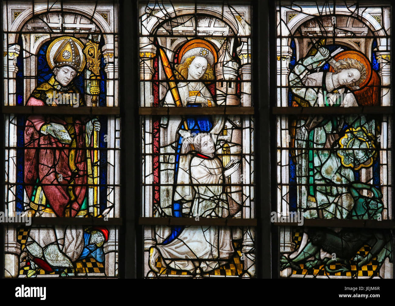 Stained Glass window in St Gummarus Church in Lier, Belgium, depicting Catholic Saints including Saint Michael the Archangel slaying Satan Stock Photo