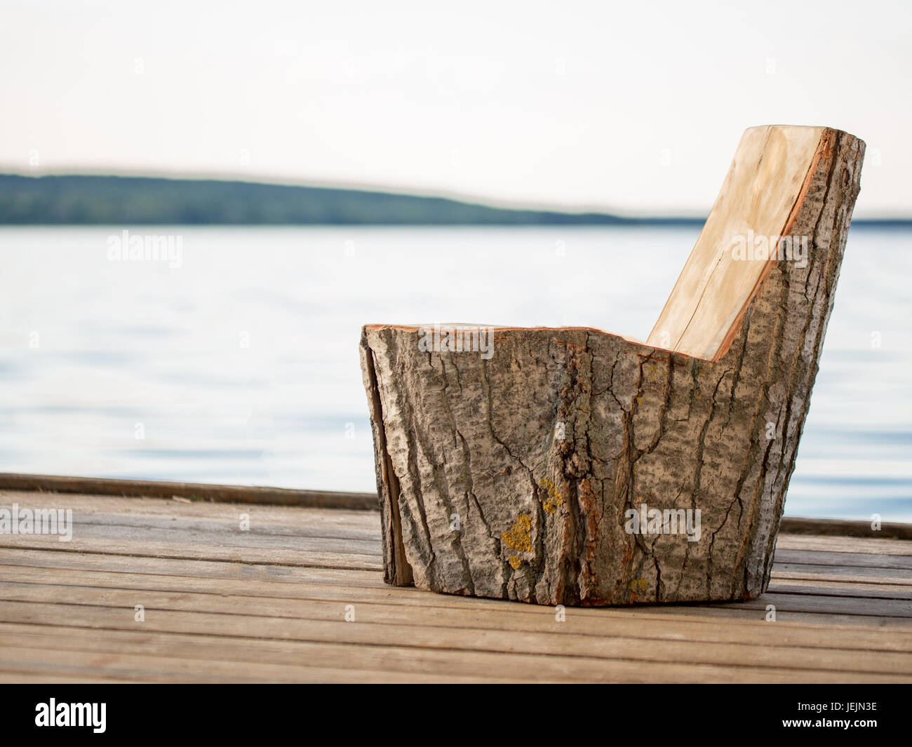 Wooden Chair Made Of Big Stump On A Fishing Pier On Lake Or