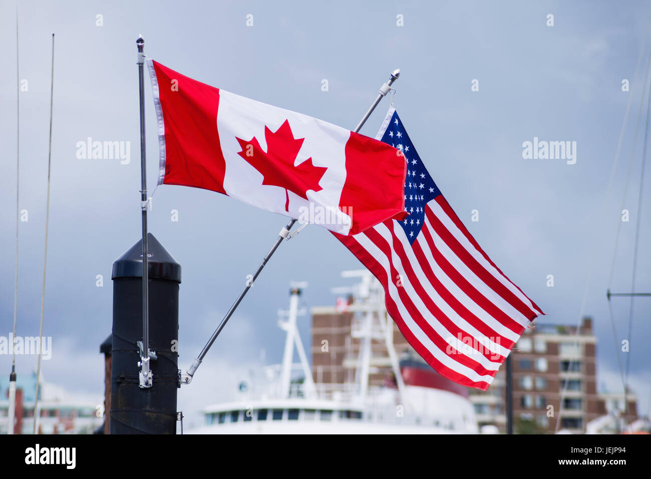 Flags of Canada Canadian and USA American blowing in wind Stock Photo