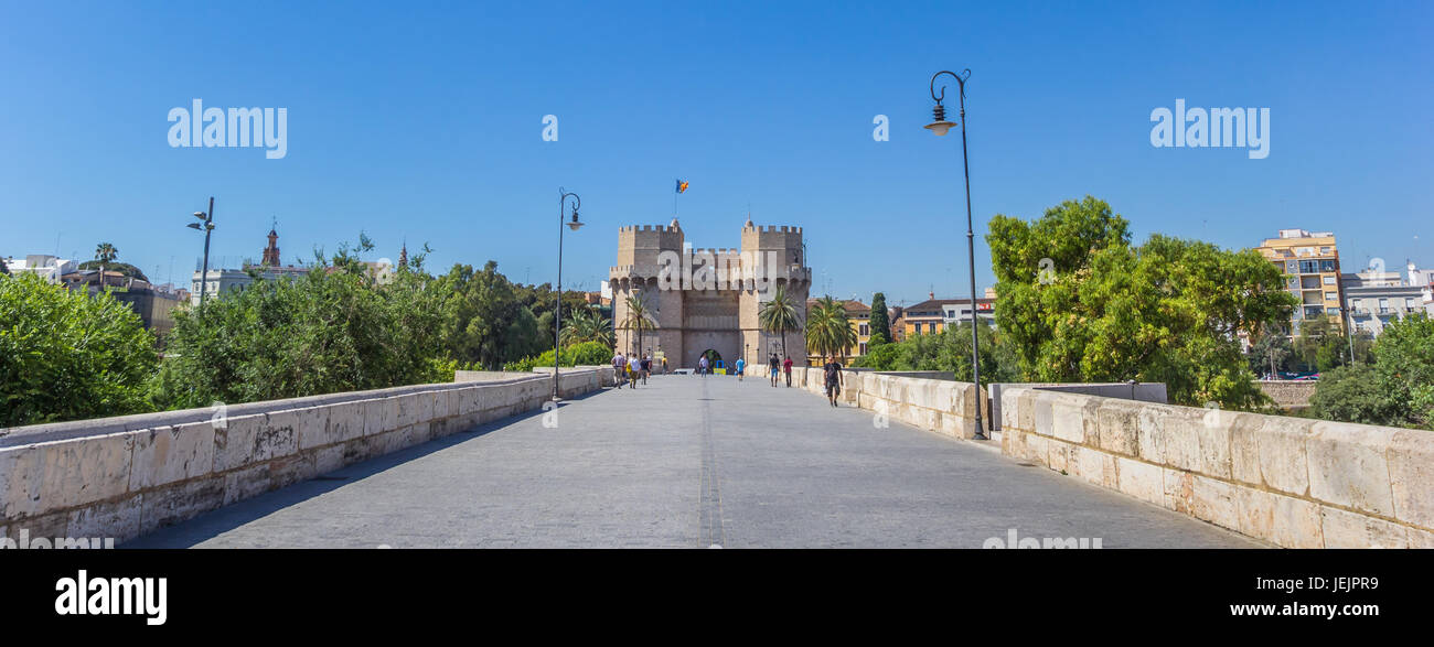 Panorama of people walking the Serranos brigde towards the historic city gate in Valencia, Spain Stock Photo