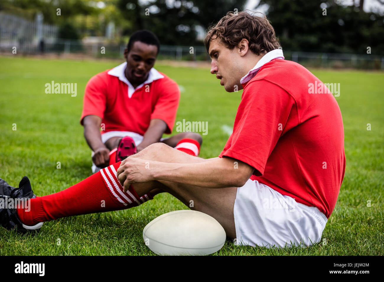 Rugby players sitting on grass before match Stock Photo - Alamy