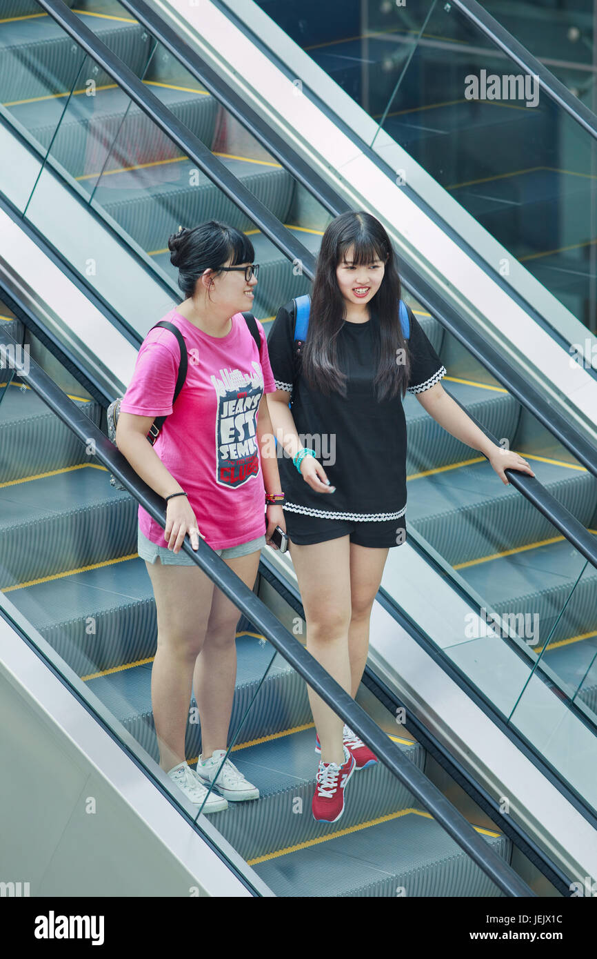 BEIJING-AUG. 2, 2015. Fashionable girls in shopping mall. First generation one-child policy consumers have opposite shopping habits from parents. Stock Photo