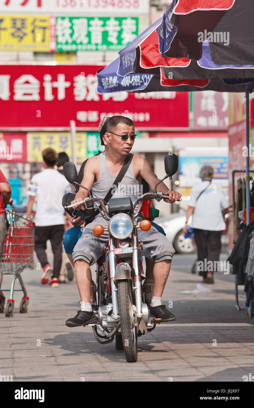 BEIJING-JULY 24, 2015. Couple on a Lifan motorcycle. Lifan is a privately owned Chinese motorcycle and automobile manufacturer in Chongqing. Stock Photo