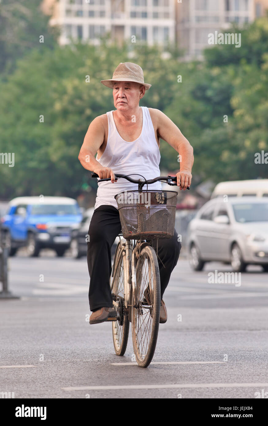 BEIJING-JULY 27, 2015. Male senior on rusty bike. China’s elderly population (60 years + older) is currently 128 million, one in every ten people. Stock Photo