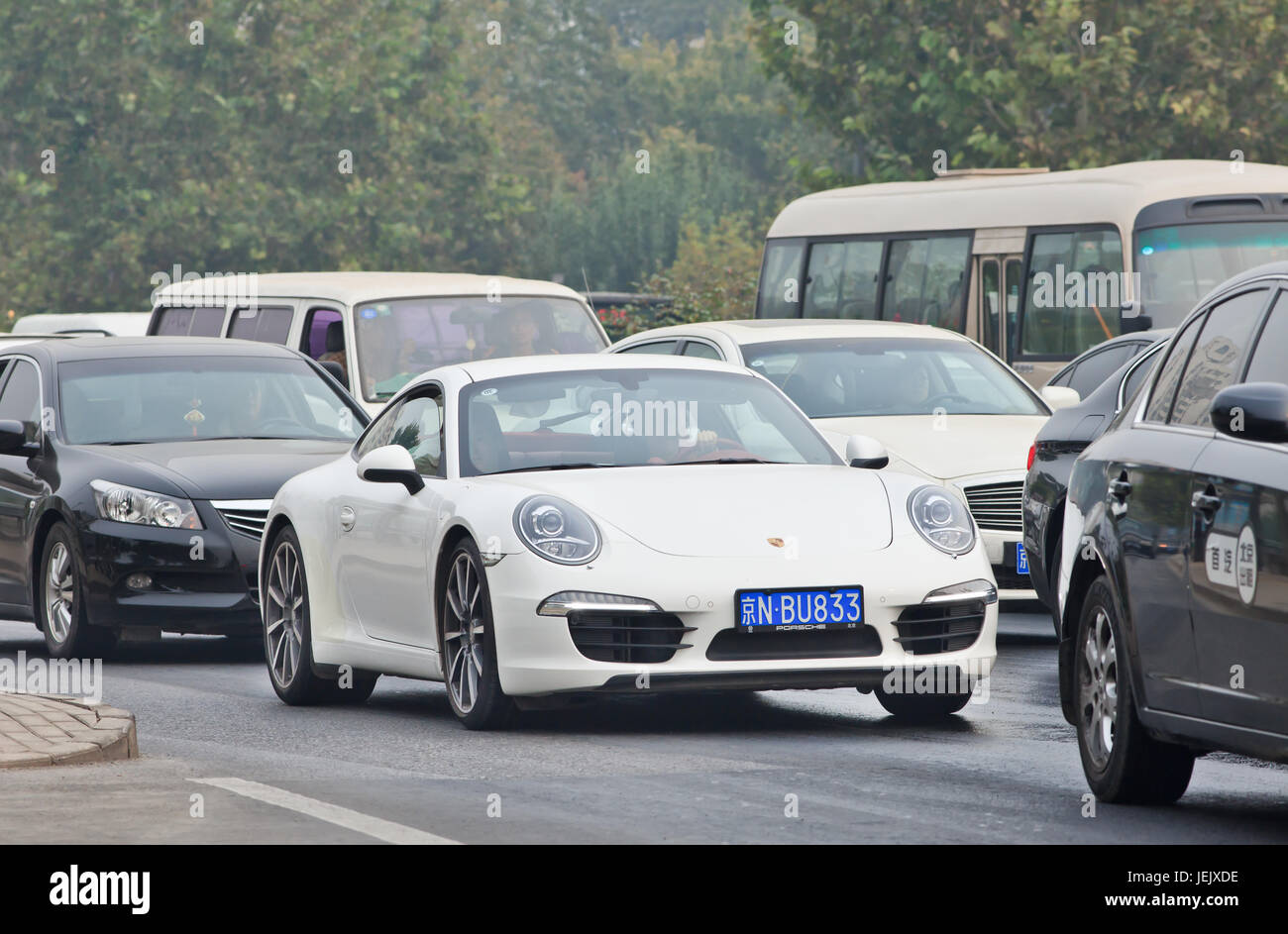 BEIJING-OCTOBER 19, 2014. Porsche 911 Carrera in Beijing traffic jam. About 120,000 luxury cars were imported into China last year. Stock Photo