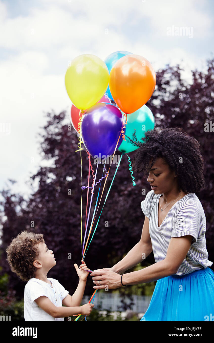 Mother with son holding bunch of balloons Stock Photo